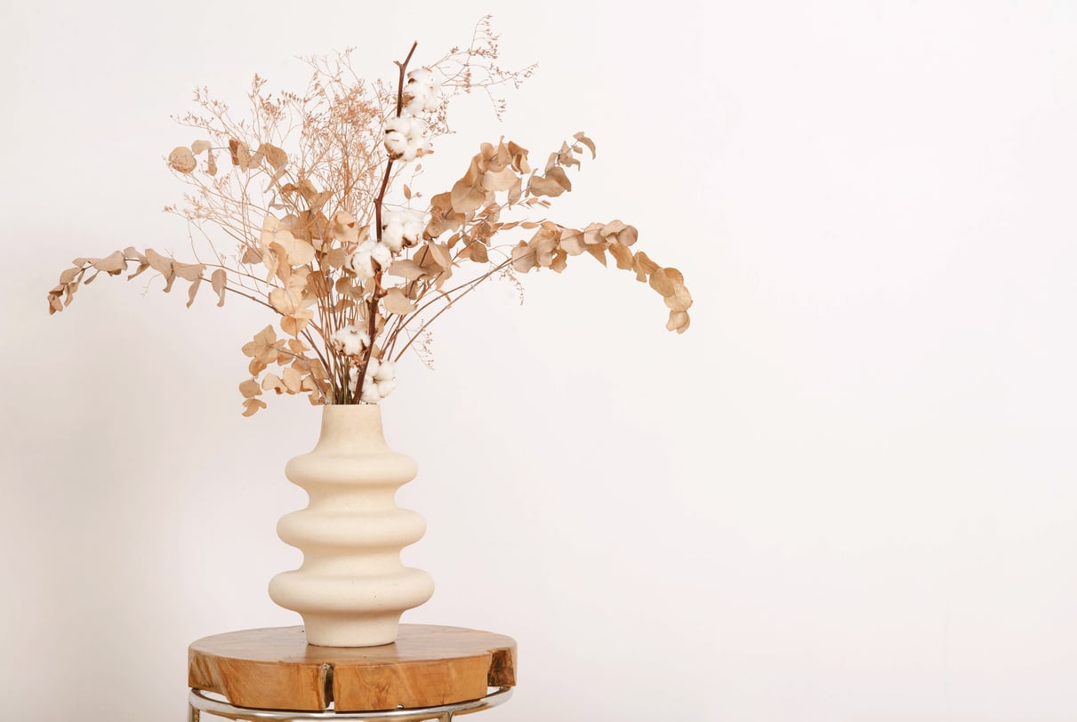 Dry brown flowers in beige vase